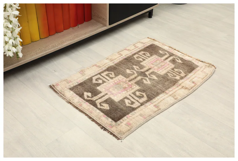 Full top view of the brown and beige tribal doormat on a white background.