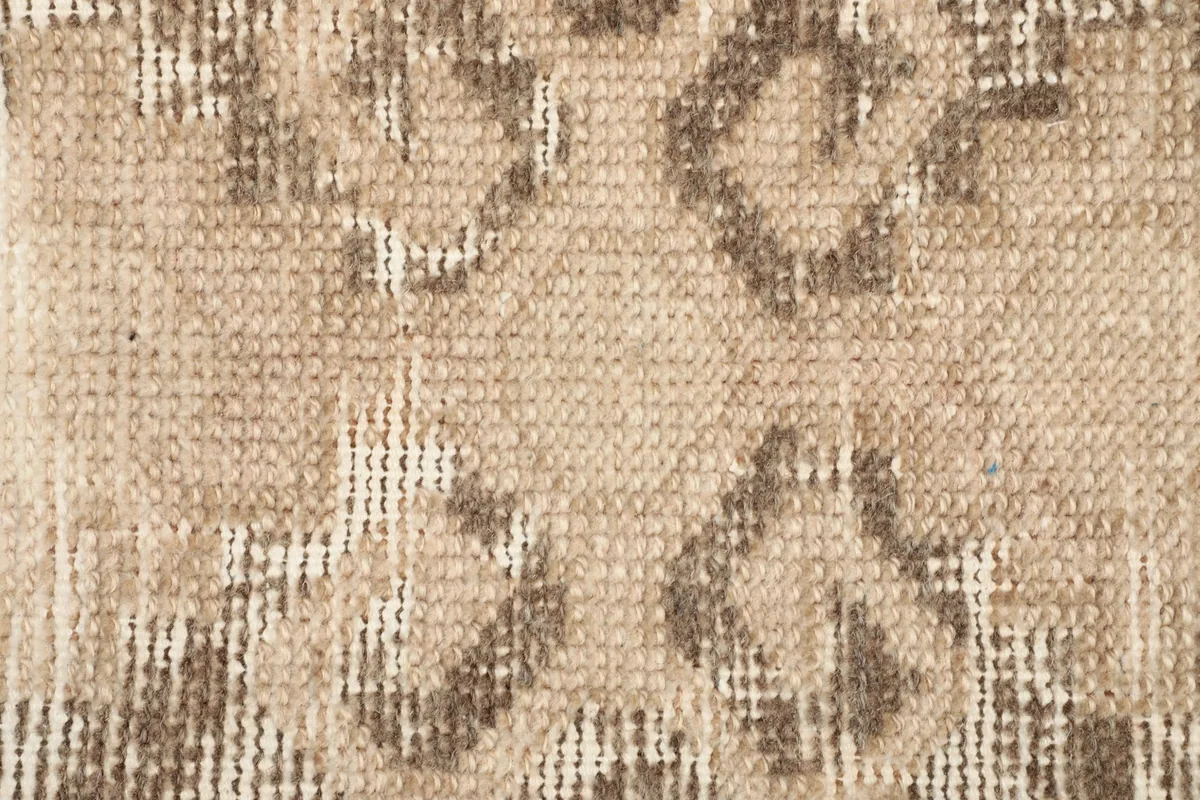 Close-up of the faded tribal geometric pattern on the distressed side of the rug.