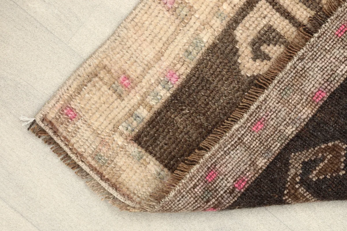 Rug folded to show the pile texture and the side profile of the hand-knotted construction.