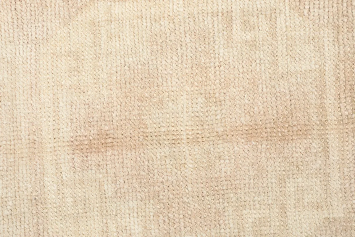 Texture shot of the low wool pile, showing the tight knotting and soft, distressed surface.