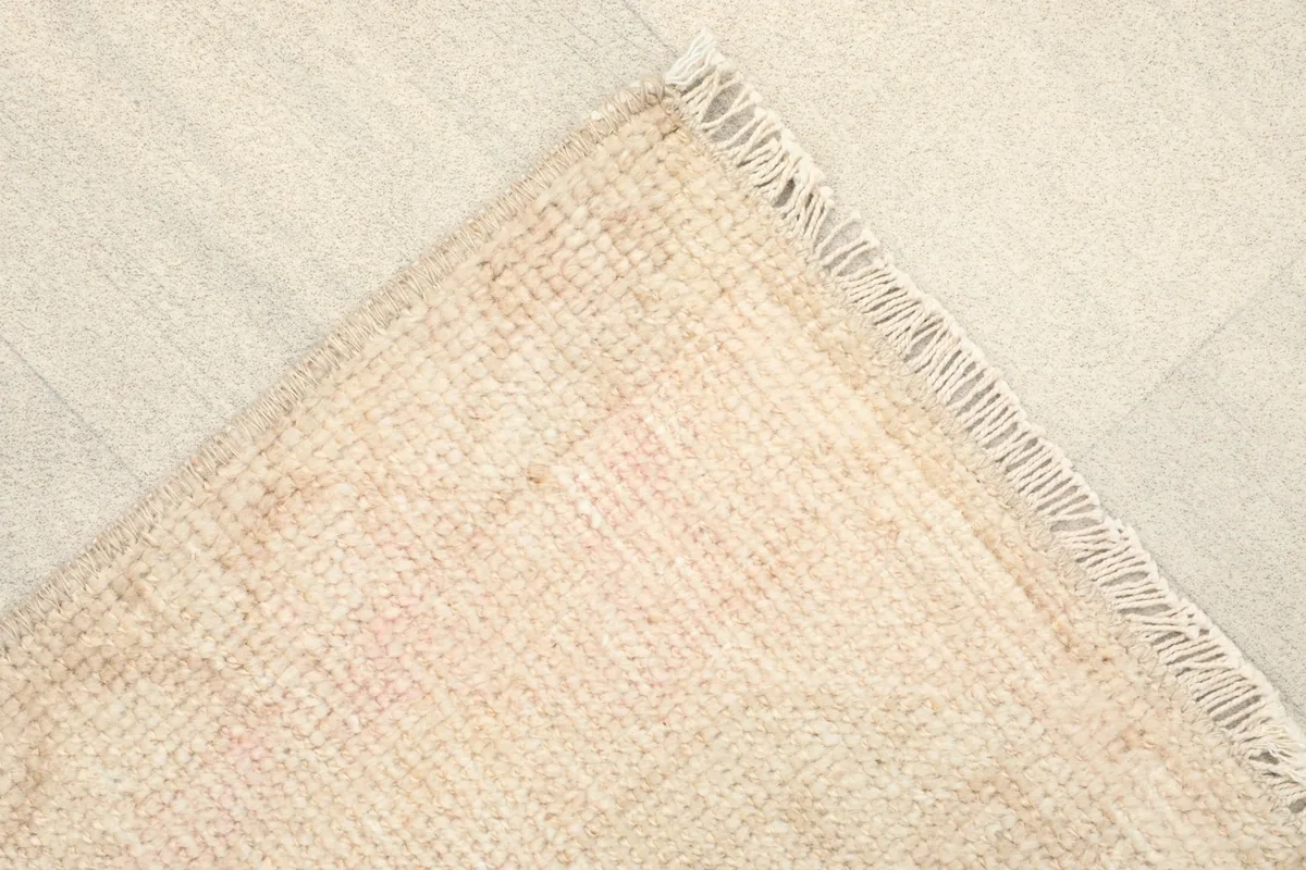 Corner view of the rug's back, displaying the cotton foundation and hand-knotted construction.
