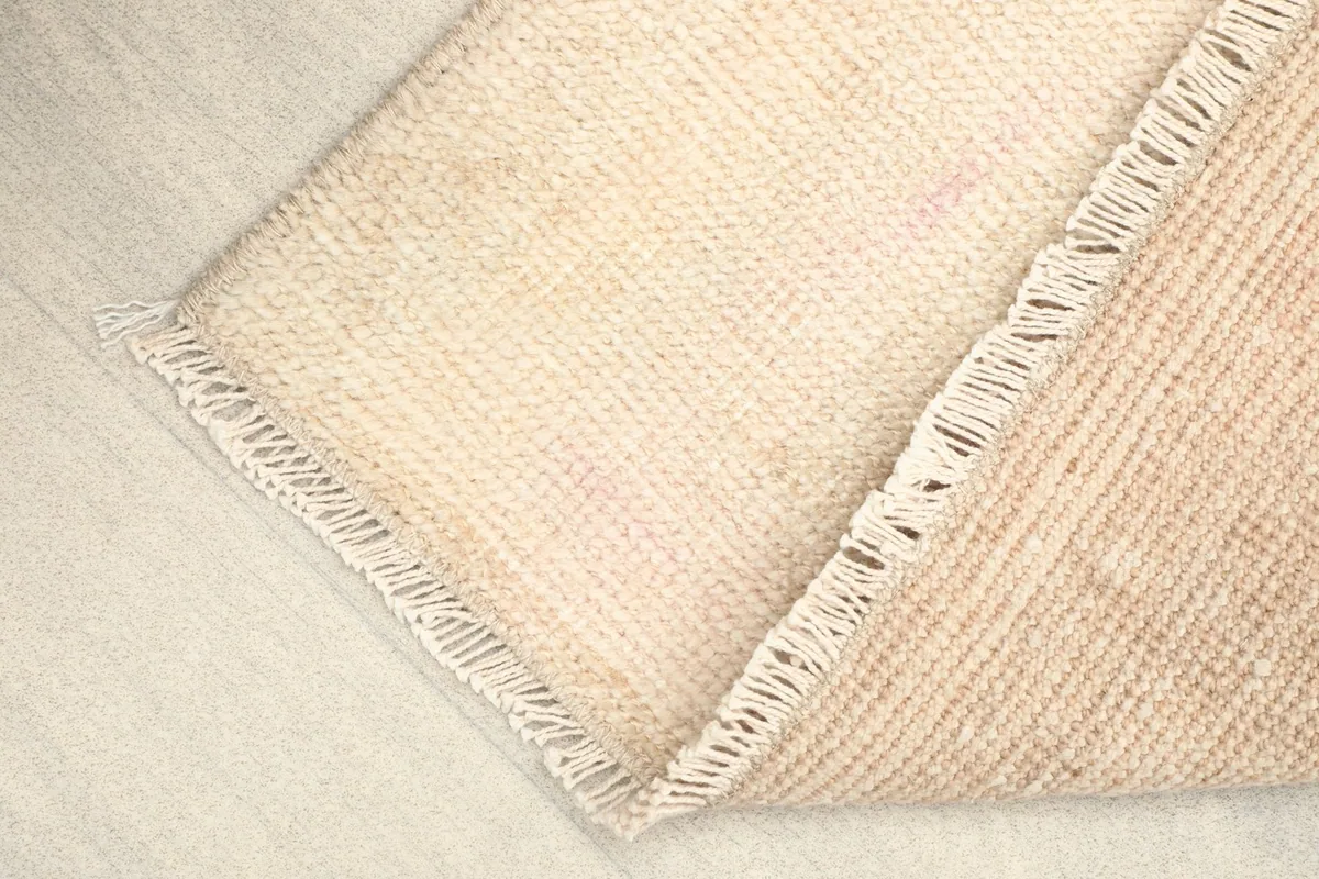 Folded corner of the rug, showing the flexibility and thickness of the hand-knotted material.