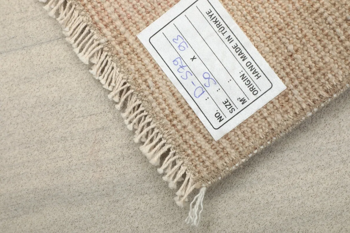 Label on the back of the rug, indicating its origin, size, and hand-made quality.