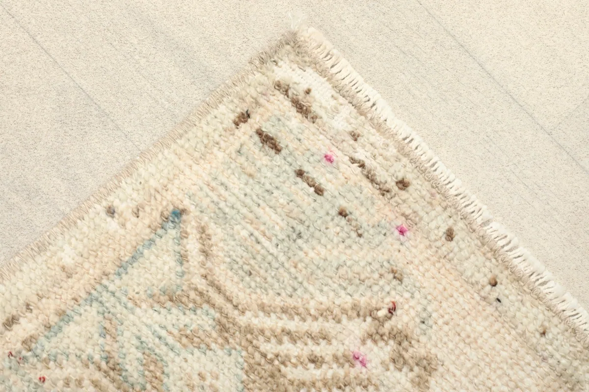 Close-up of a corner of the rug, showing the hand-knotted wool pile and subtle color variations.