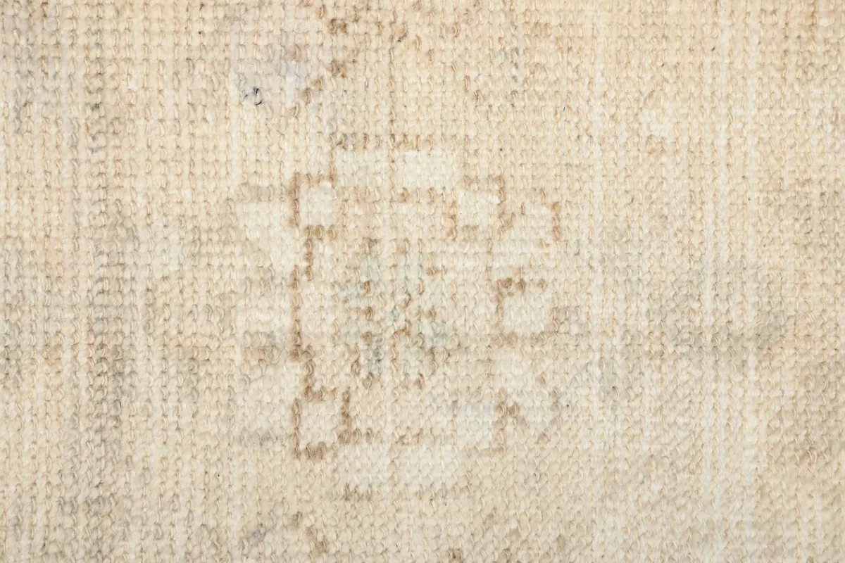 Close-up of the low wool pile, showing the intricate knotting and the subtle sheen of the fibers.