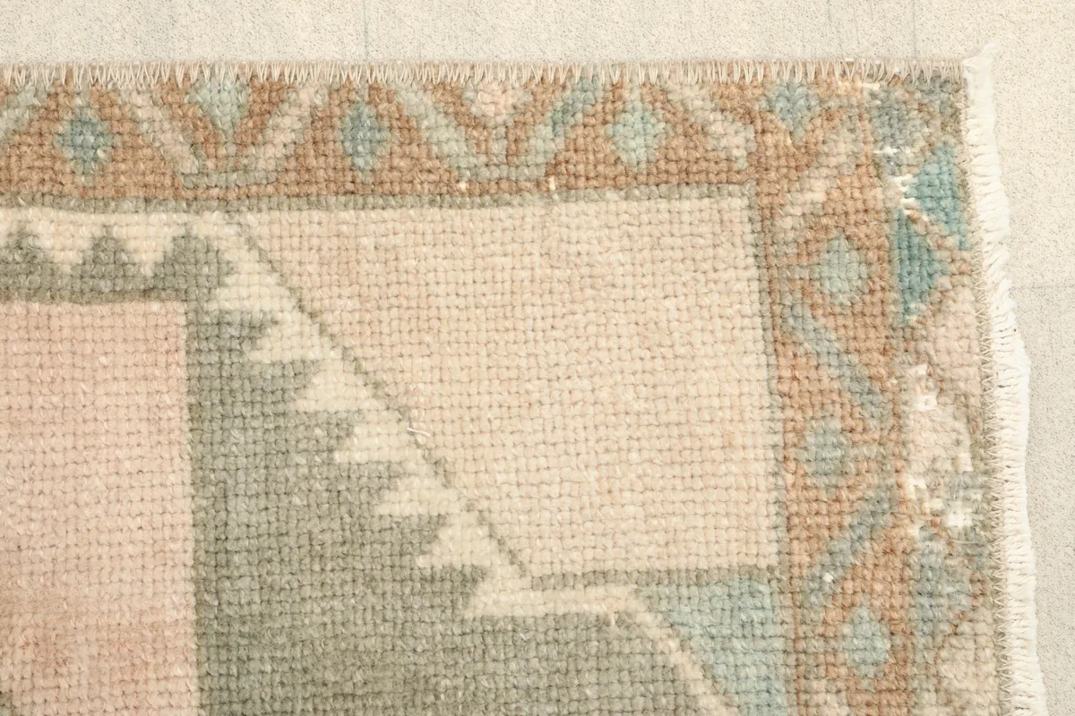 Close-up of the border design with small rust and blue geometric elements