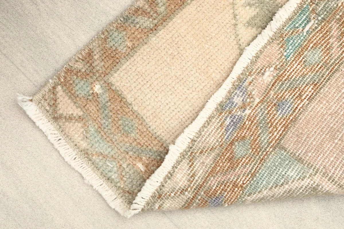 View of the rug's cotton foundation and the back of the hand-knotted wool