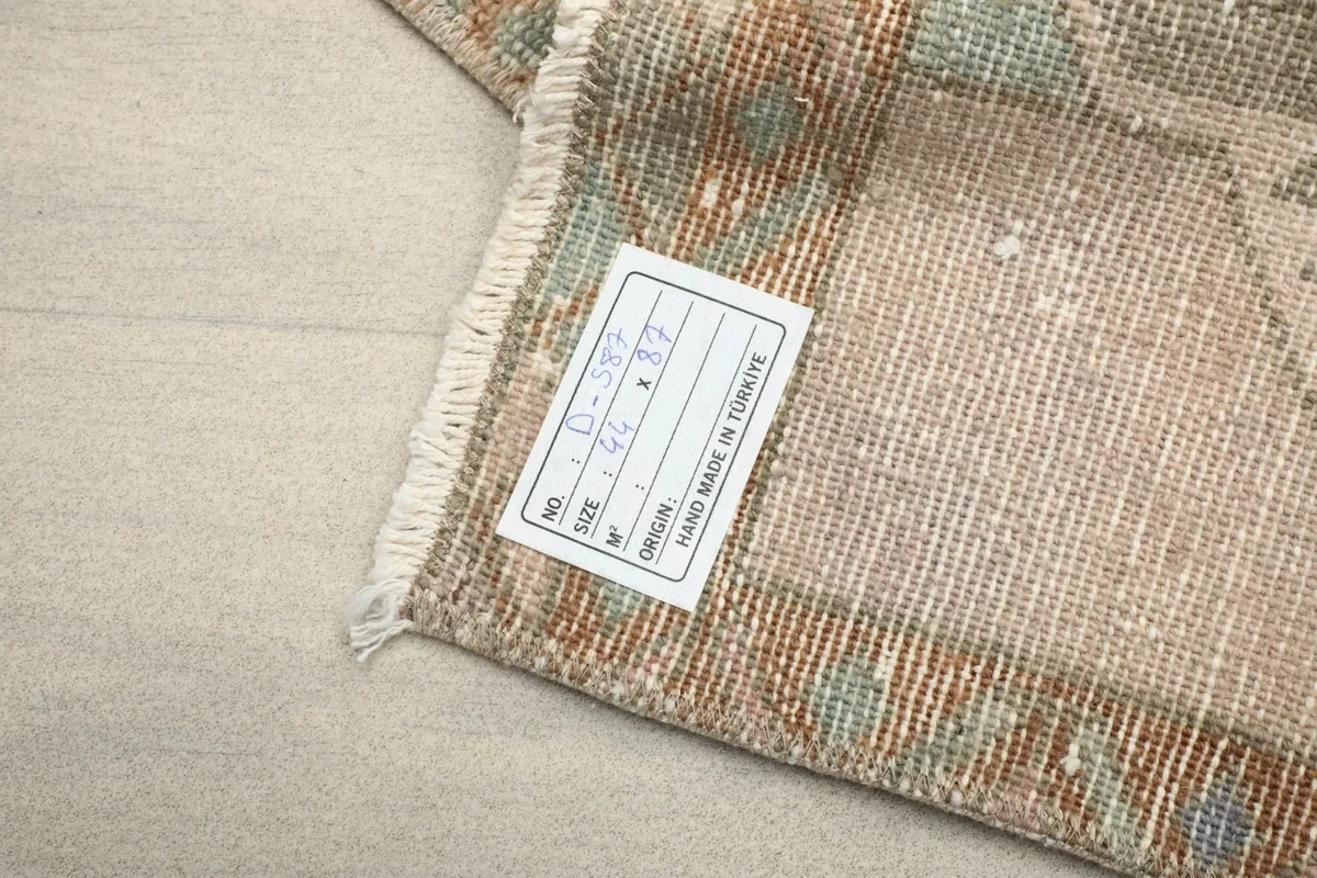 Label on the back of the rug indicating its origin and hand-knotted nature