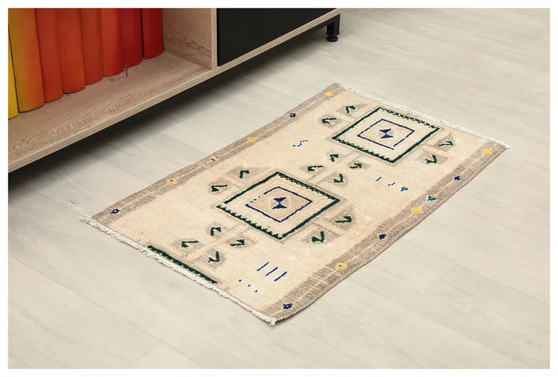 Full top view of a beige and navy geometric vintage Anatolian area rug on a light floor.
