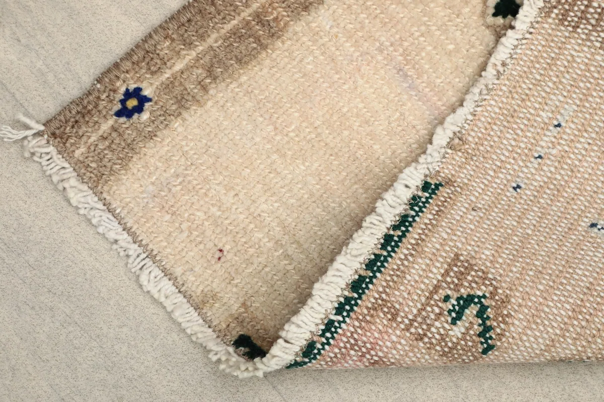 View of the back of the hand-knotted wool rug, showing the cotton foundation and knotting.