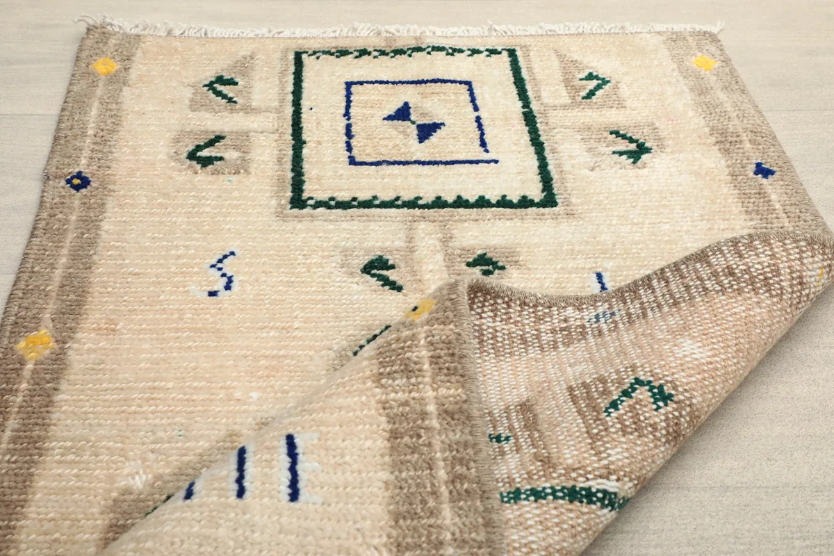 Angled view with one corner folded back, showing the thickness and construction of the rug.