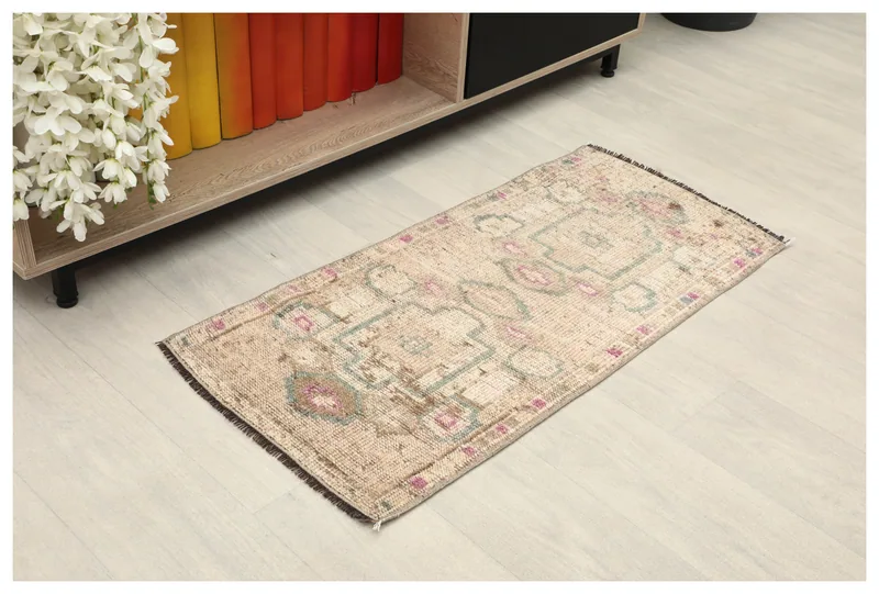 Top view of the 1'6" x 3'1" beige vintage Anatolian doormat with green and rose geometric patterns.