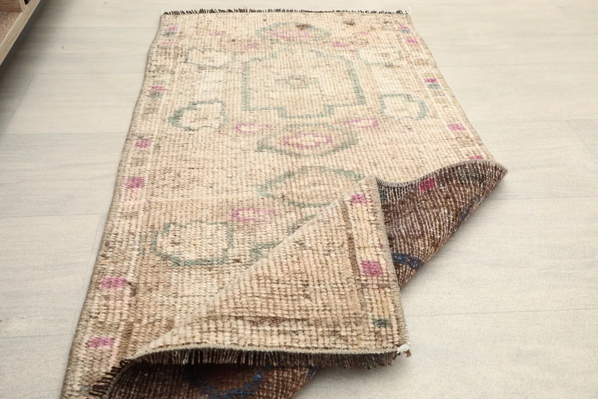 The doormat placed in a room setting, partially folded to show its flexibility and size.