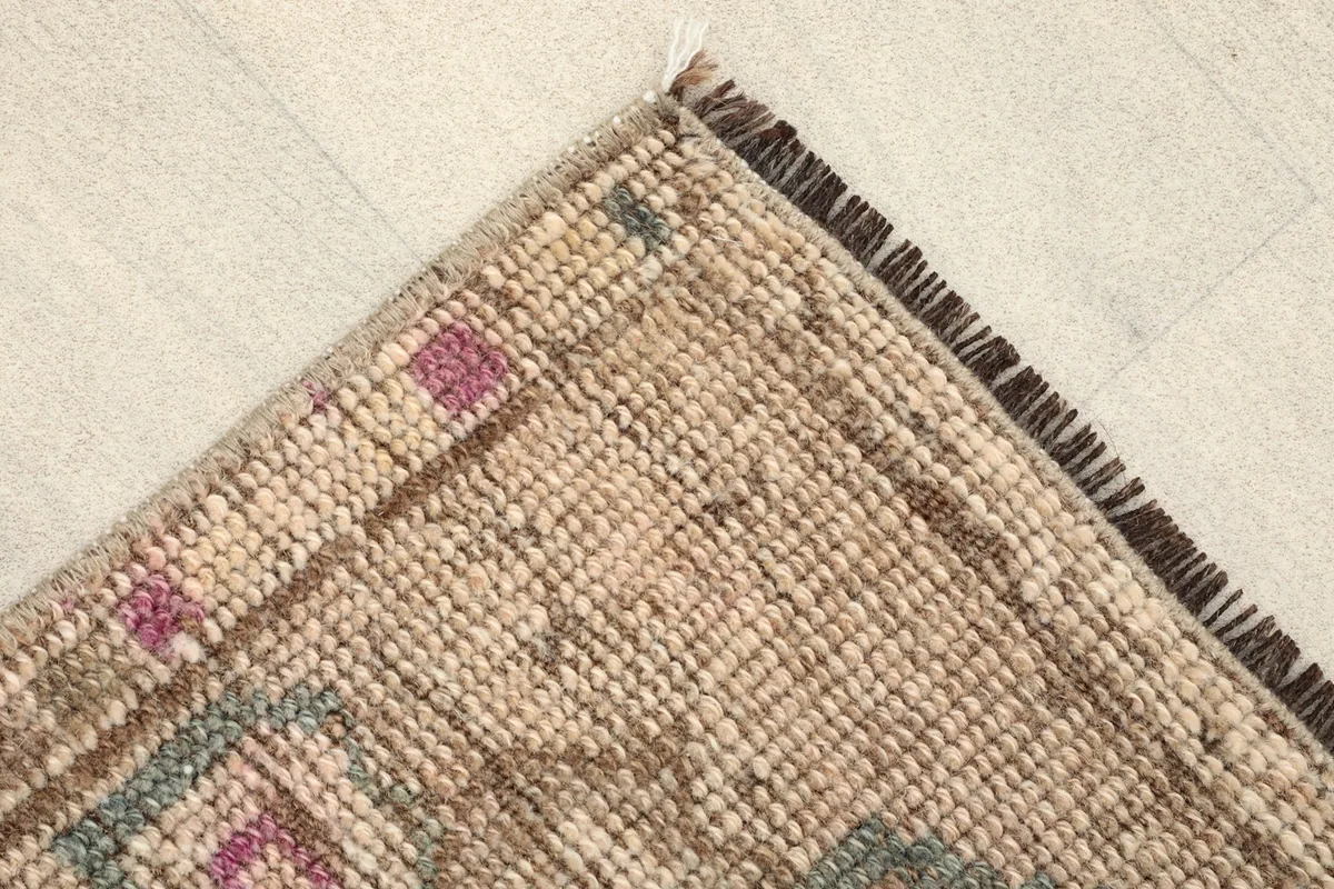 Corner detail of the rug showing the tight knotting and short fringe along one edge.