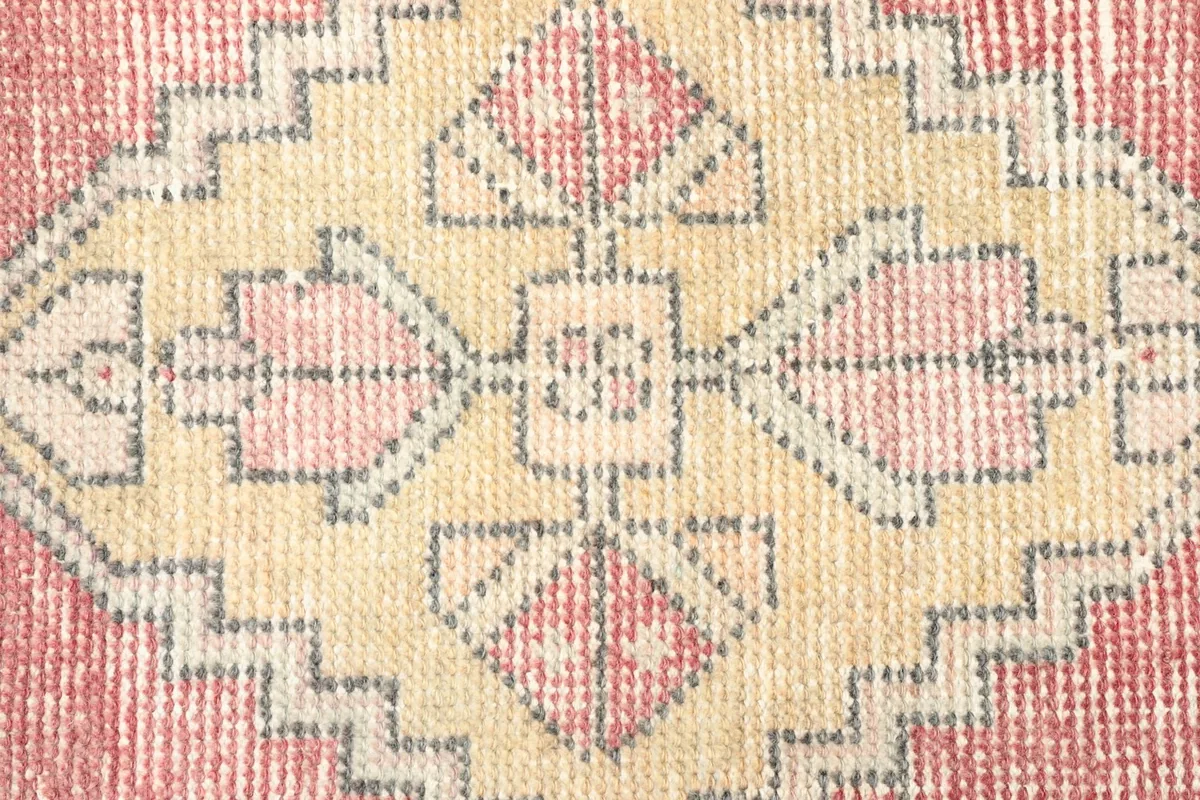 Close-up detail of the central geometric medallion with rose, gold, and gray elements.
