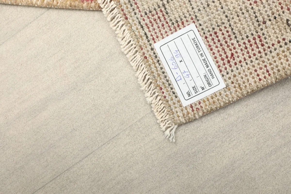 Close-up of the rug's back, showing the tight hand-knotted construction and care label.