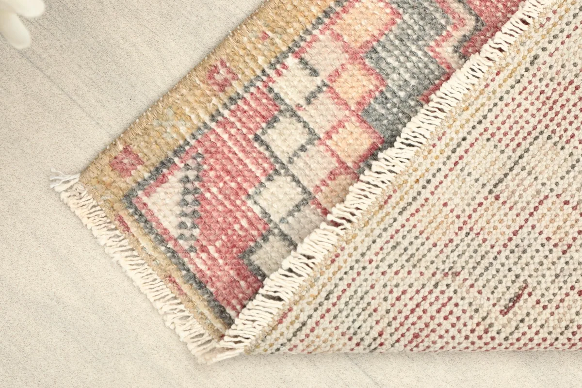 View of the rug folded, showing the hand-knotted wool pile and cotton foundation.