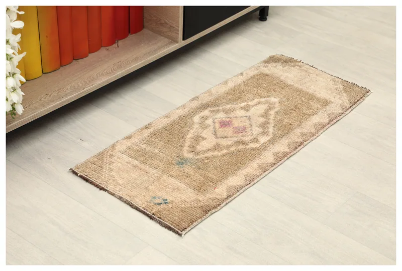 Full top view of the 1x3 tan vintage Anatolian doormat on a light floor.