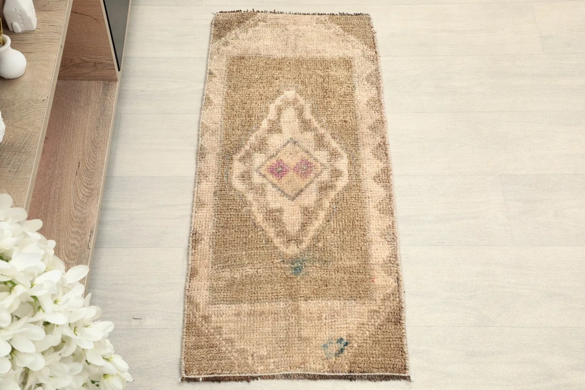 Overhead view of the small tan doormat, showcasing its tribal medallion design.