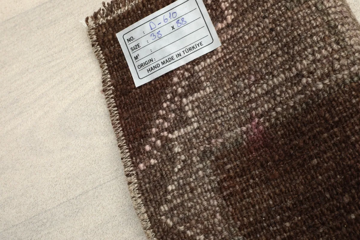 Label on the back of the rug indicating its origin and hand-knotted nature.