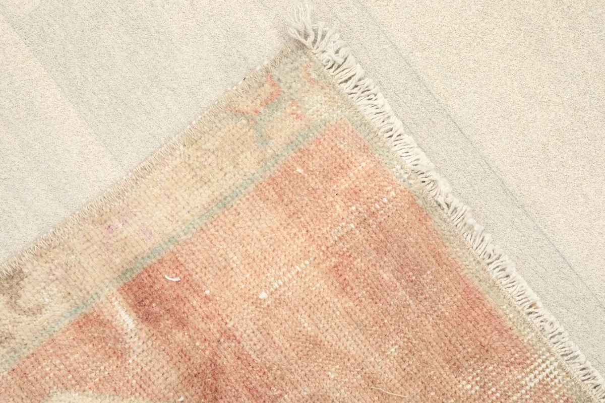 Angled view highlighting the soft rose border and corner of the doormat