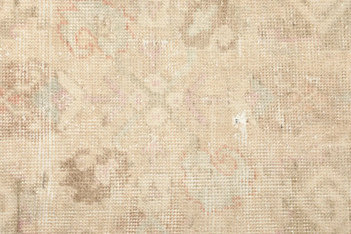 Detailed view of the low wool pile and worn texture of the vintage rug