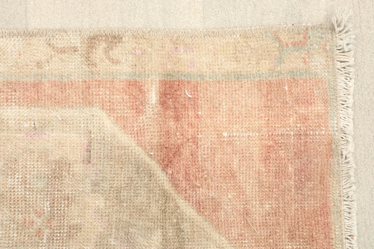 Close-up of the rose-colored border and the faded patterns