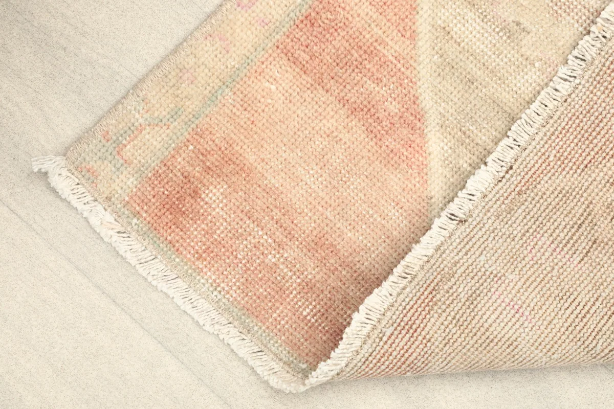 Corner of the rug folded to show the thickness and flexibility of the vintage wool