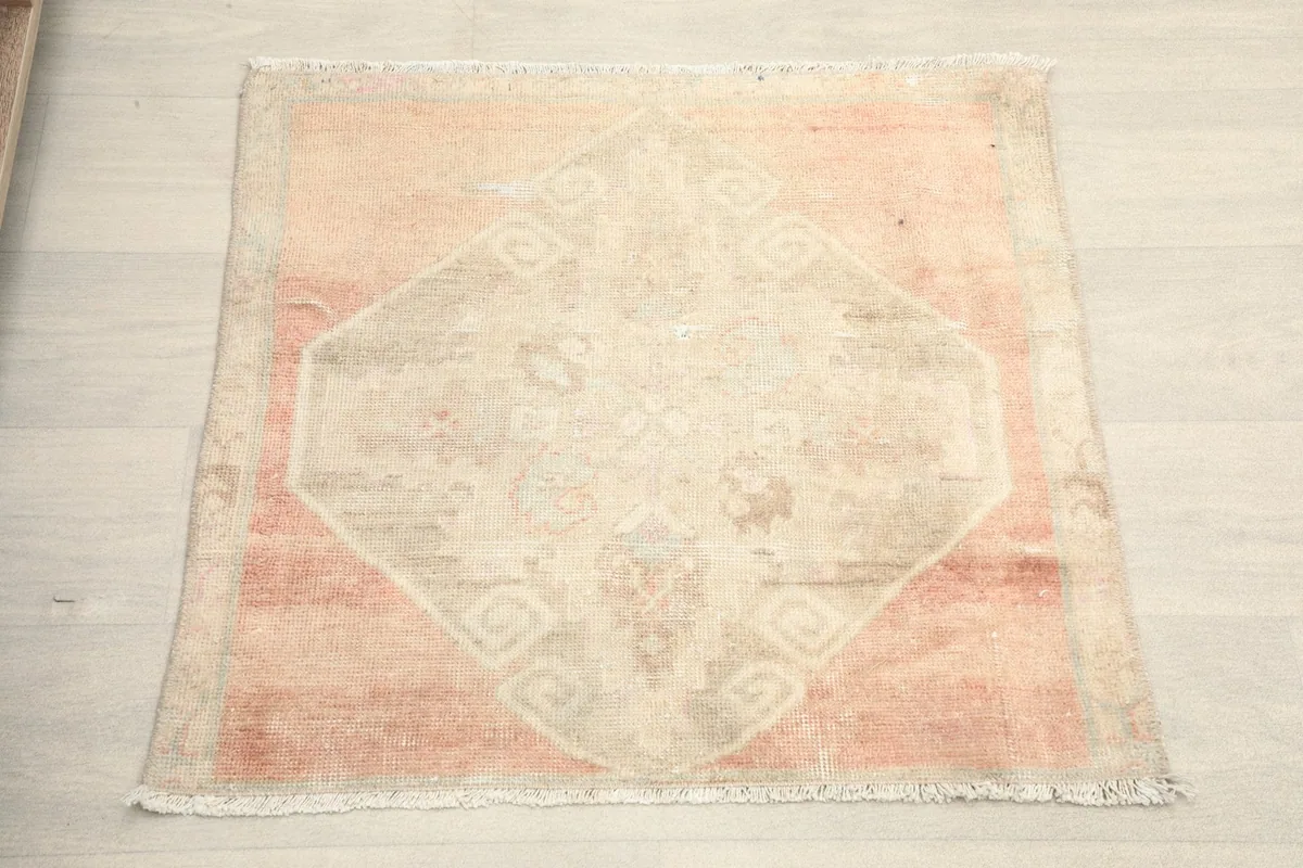 Overhead view of the mini rug showing its square shape and central geometric motif