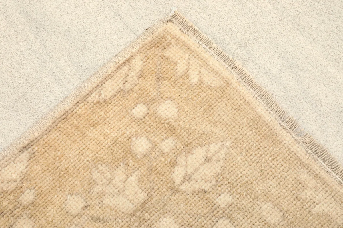 Close-up of a corner, showing the subtle floral pattern and the finished edge of the rug.