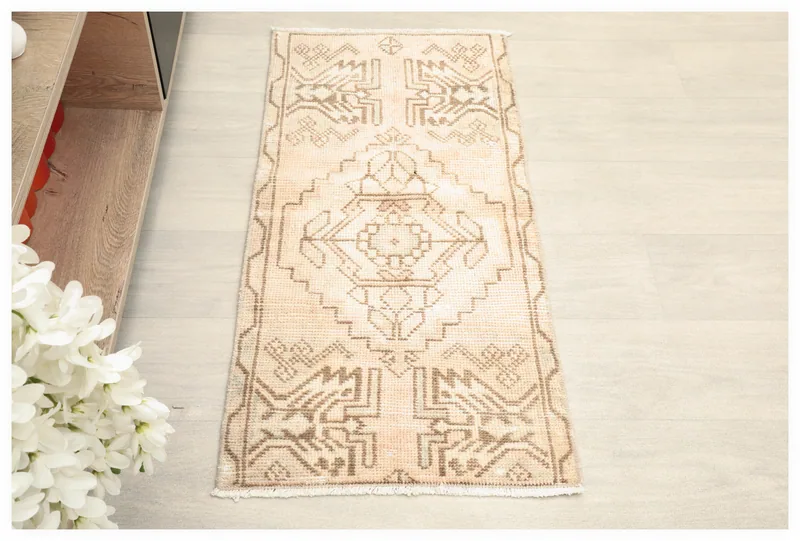 Full overhead view of the beige and brown vintage Anatolian tribal rug on a white background