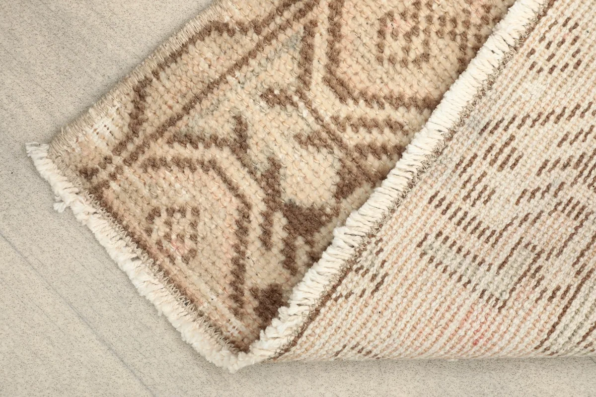 Close-up view of the low wool pile and the hand-knotted texture of the vintage rug