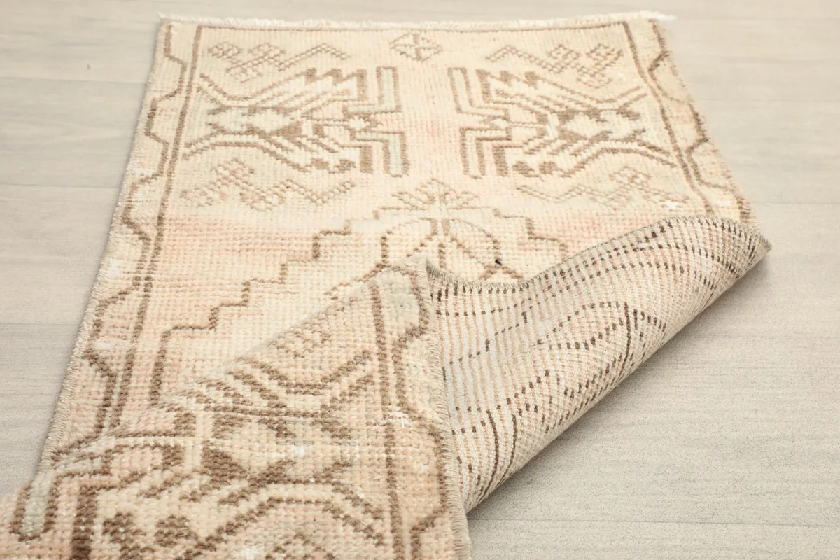 View of the rug's underside, showing the cotton foundation and reverse of the hand-knotted pattern