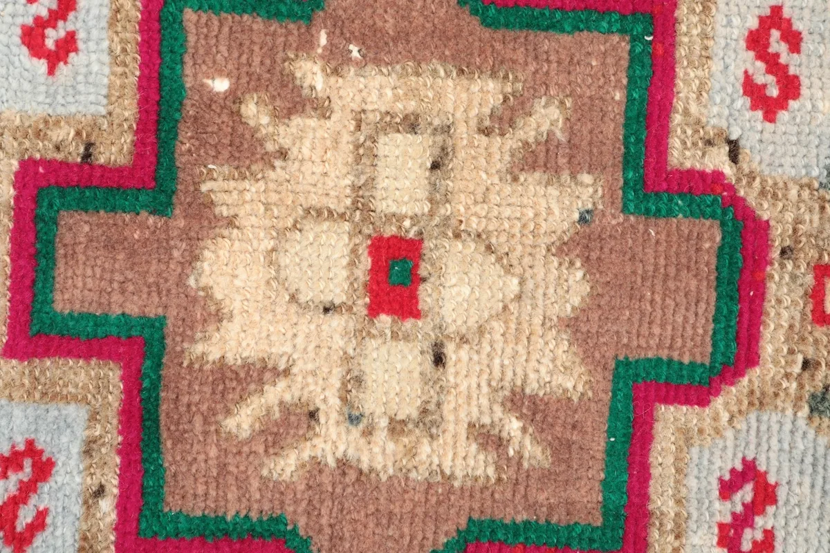 Detailed shot of the central medallion, showing the intricate hand-knotted wool pile and color variations.