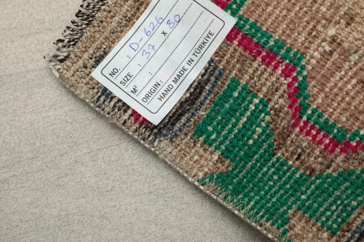 View of the rug's back with a product tag, indicating its origin as hand-made in Turkey.
