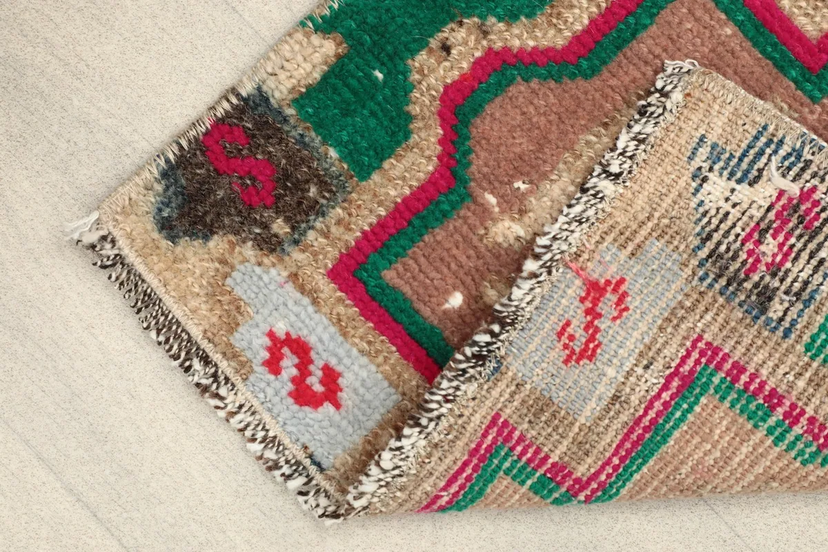 Angled view with one corner folded back, displaying the hand-knotted construction and the backside of the rug.