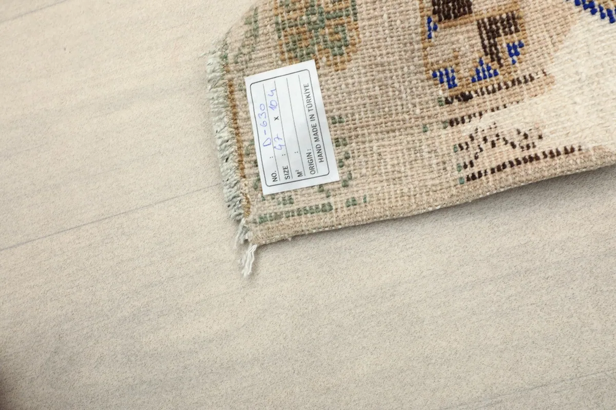 Close-up of the back of the rug, showing the cotton foundation and a small label.