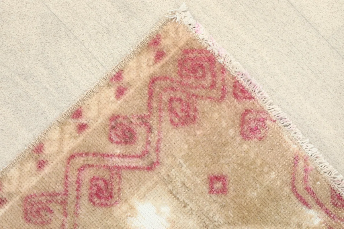 Corner detail of the rug, showcasing the rose border design and the short fringe.