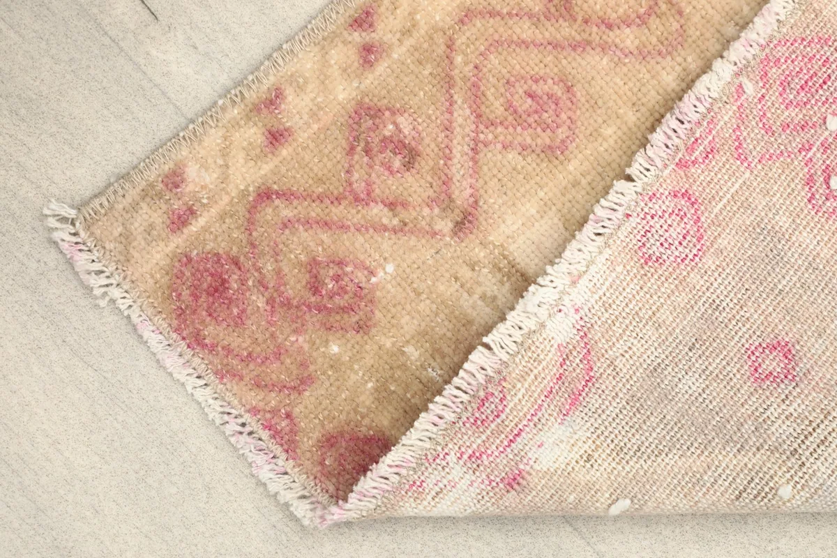 Partial view of the rug's back, revealing the hand-knotted construction and cotton foundation.
