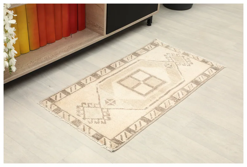 Full top view of the 1'7" x 3'1" cream and brown geometric Anatolian rug on a white background.