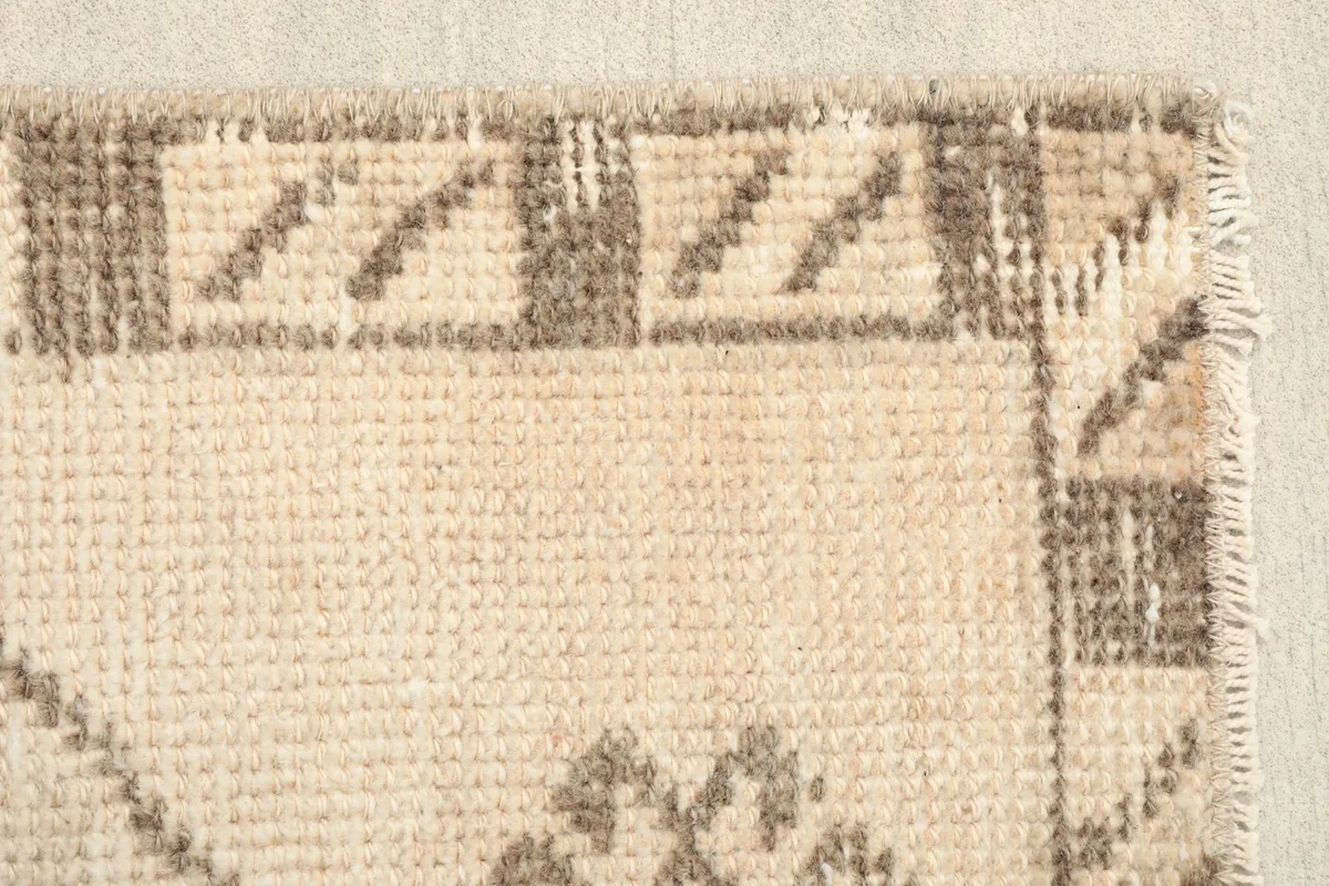 Close-up of the geometric border pattern and the edge of the vintage Anatolian rug.