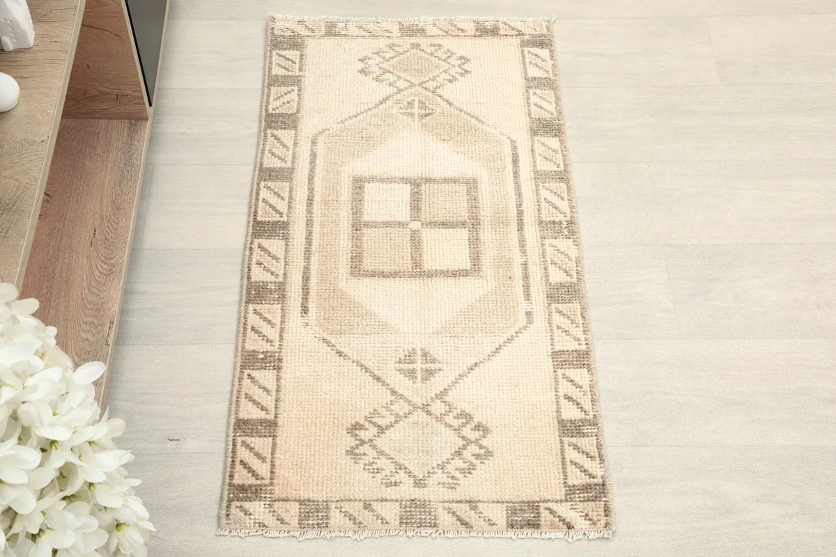 Overhead view of the vintage Anatolian doormat, highlighting the central geometric design.
