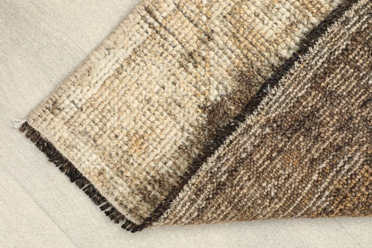 Rug folded to show the cotton foundation on the back and the wool pile on the front
