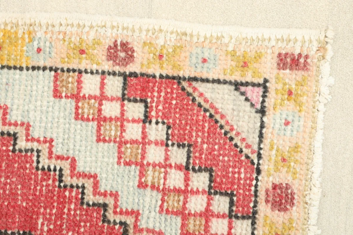 Close-up of a corner, showcasing the stepped geometric patterns and the subtle color shifts in the pile.
