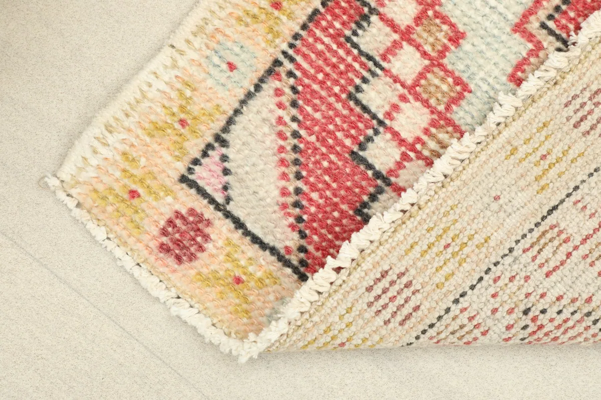 View of the back of the rug, revealing the hand-knotted cotton foundation and wool knots.