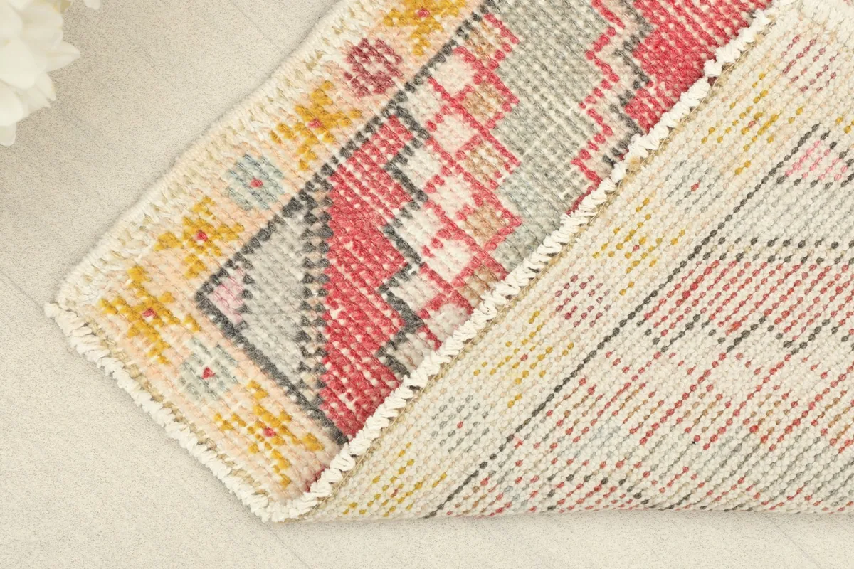 Folded rug displaying the wool pile on the front and cotton foundation on the back
