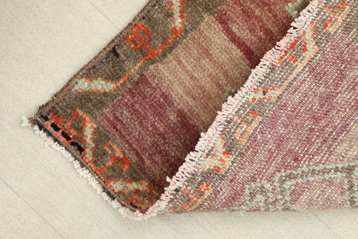 View of the rug's underside, revealing the hand-knotted cotton foundation.