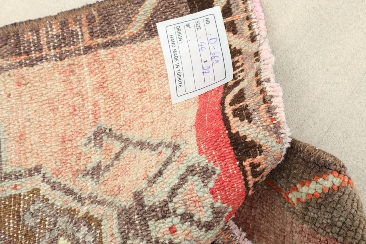 Close-up of the rug's back with the product label, showing hand-knotted detail.