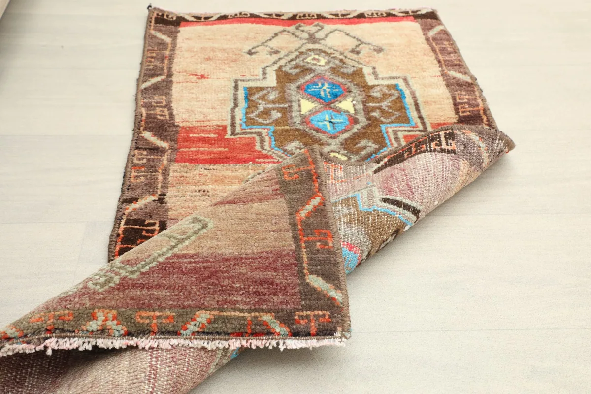 The doormat partially folded, showcasing both the top and underside textures.