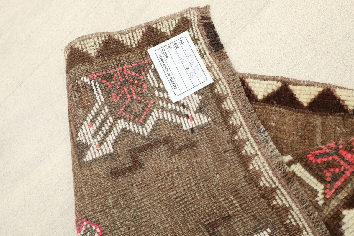 View of the rug's reverse side and edge, showing the hand-knotted construction and care label